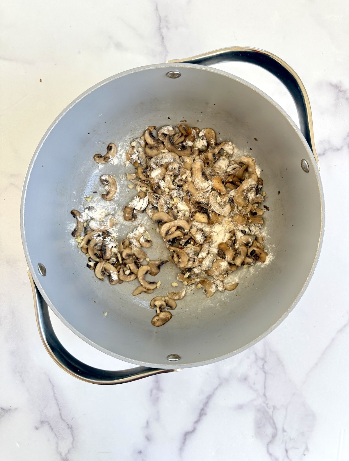 Flour and sauteed mushrooms in a large pot.