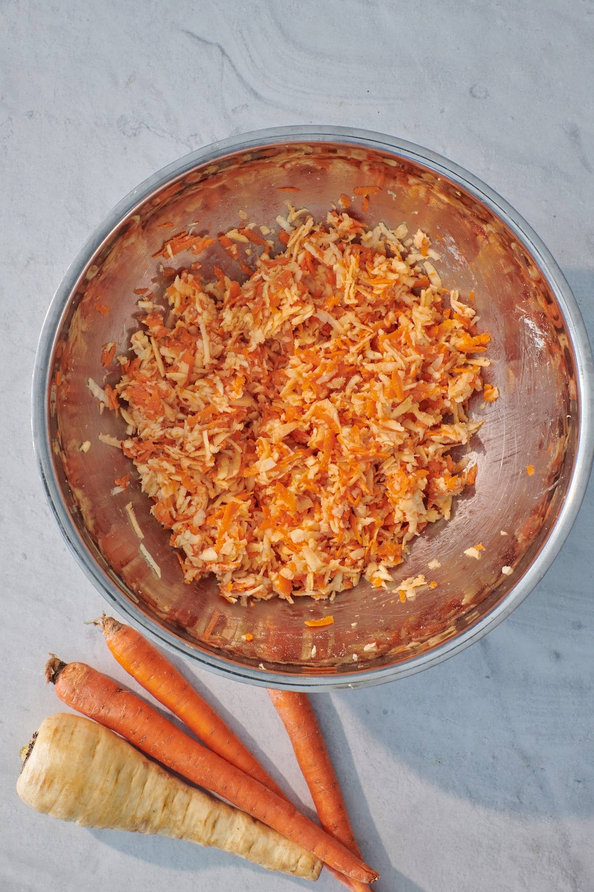 Carrot parsnip latke mixture in a bowl.