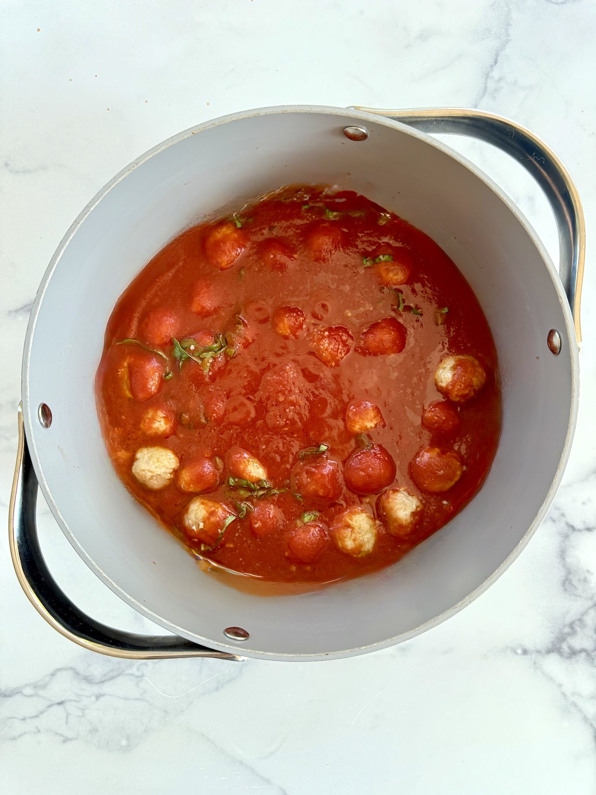 Tomato sauce with meatballs in a large pot.
