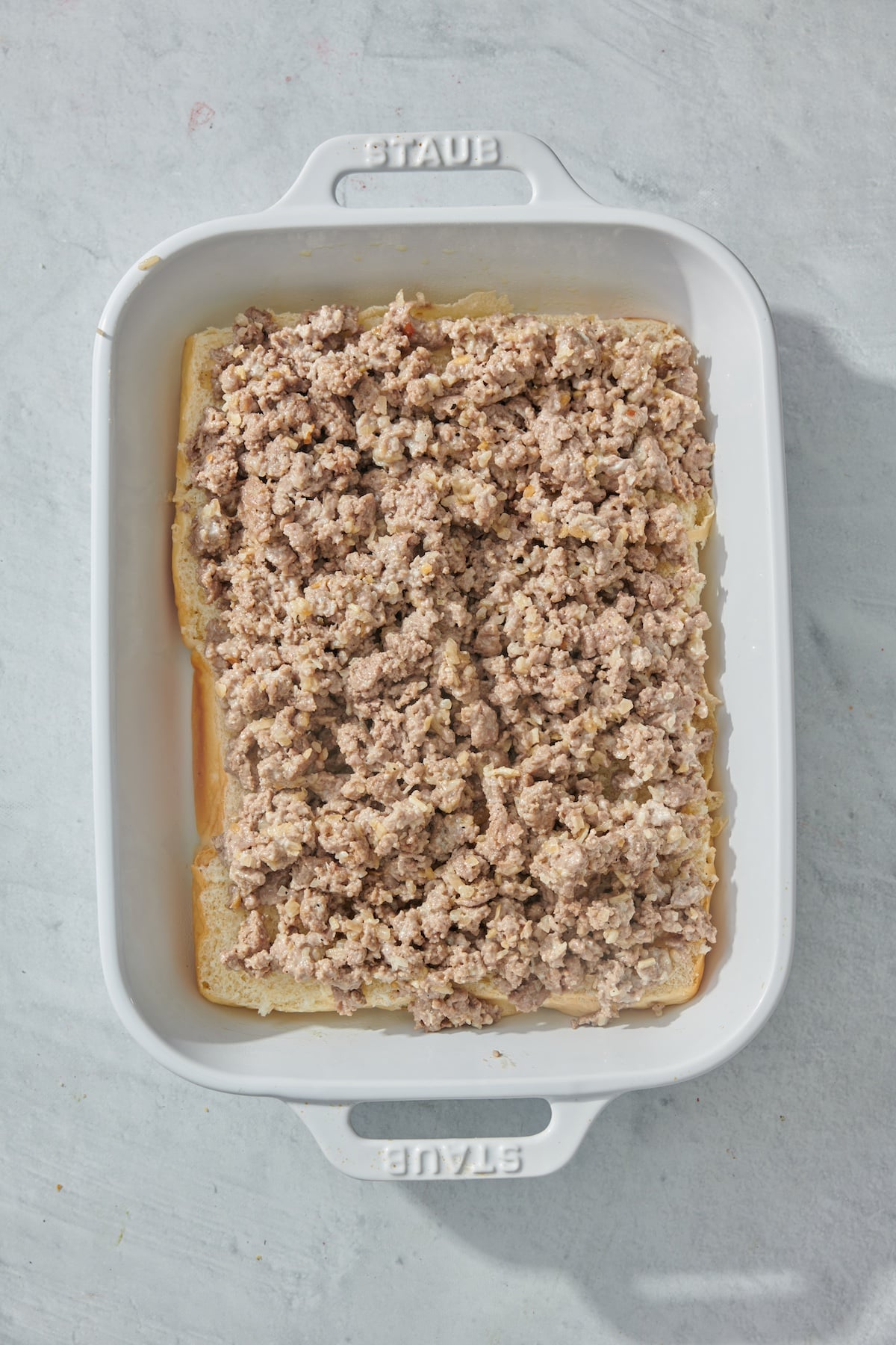 Ground beef layered on top of Hawaiian rolls.