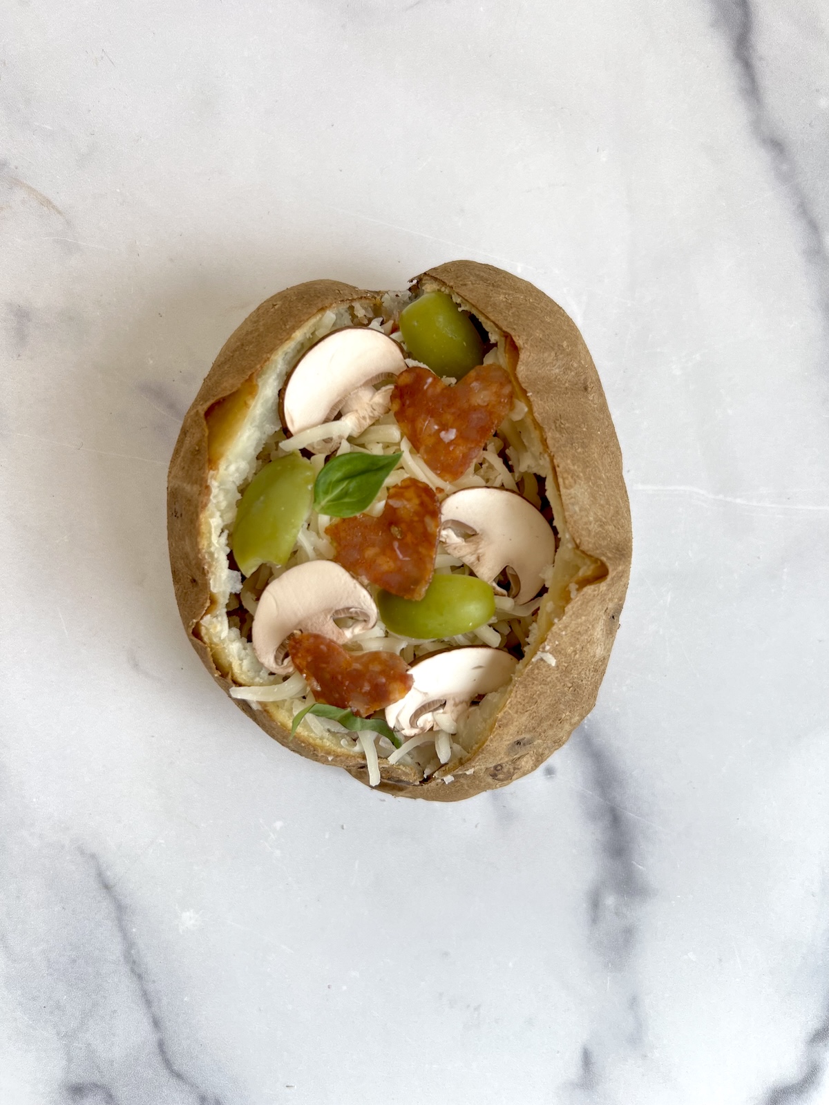 Pizza stuffed baked potato before being baked.