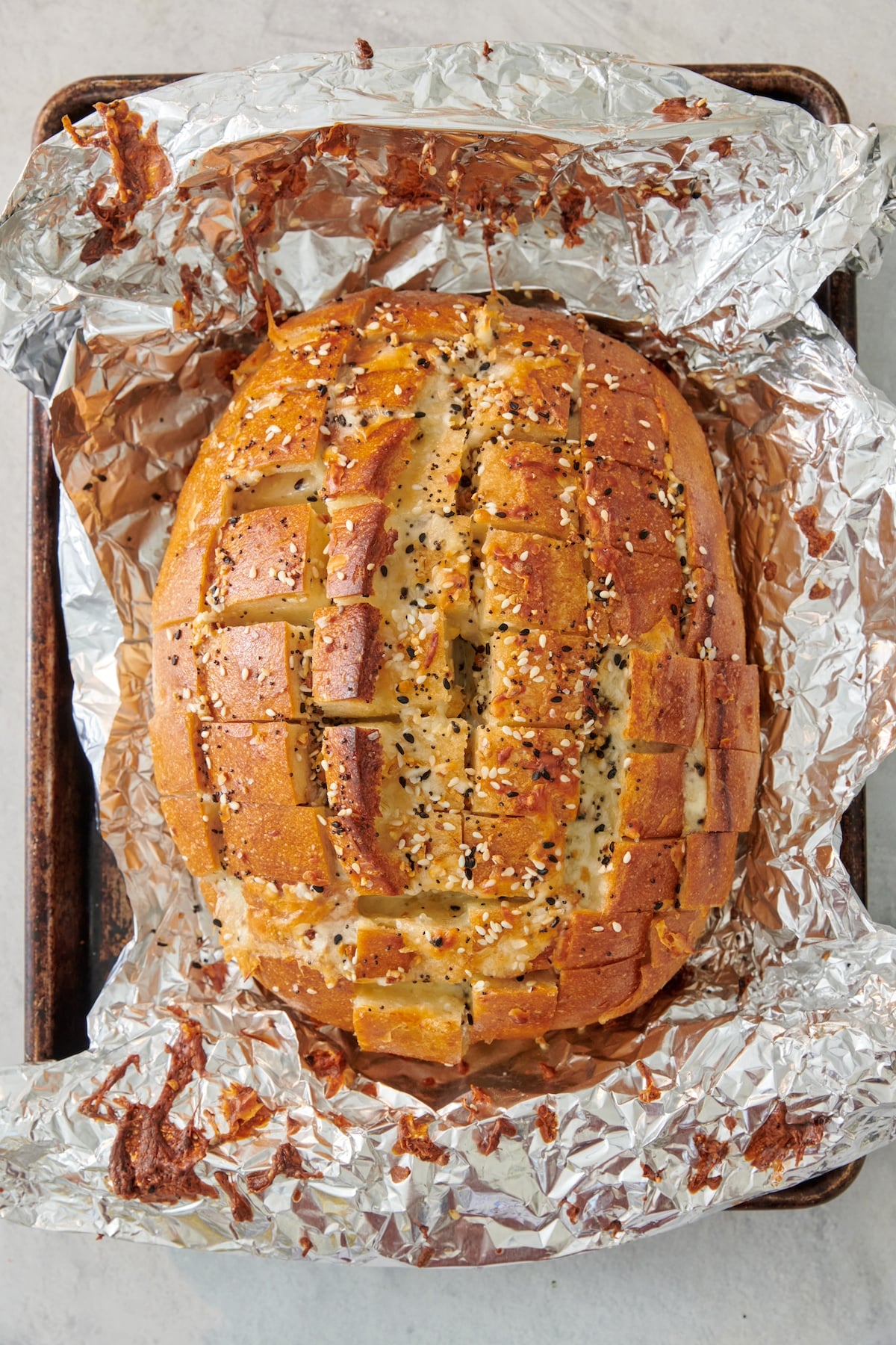 Pull apart cheese bread on a sheet of aluminum foil.