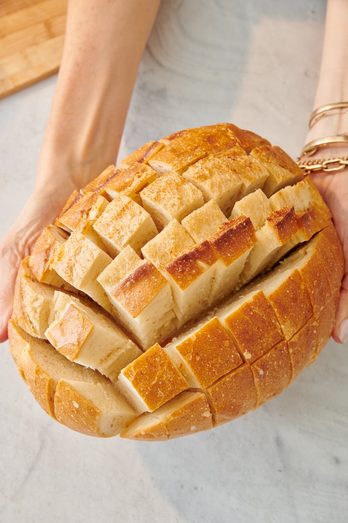 Sourdough loaf cut crosswise and lengthwise to create a grid pattern.