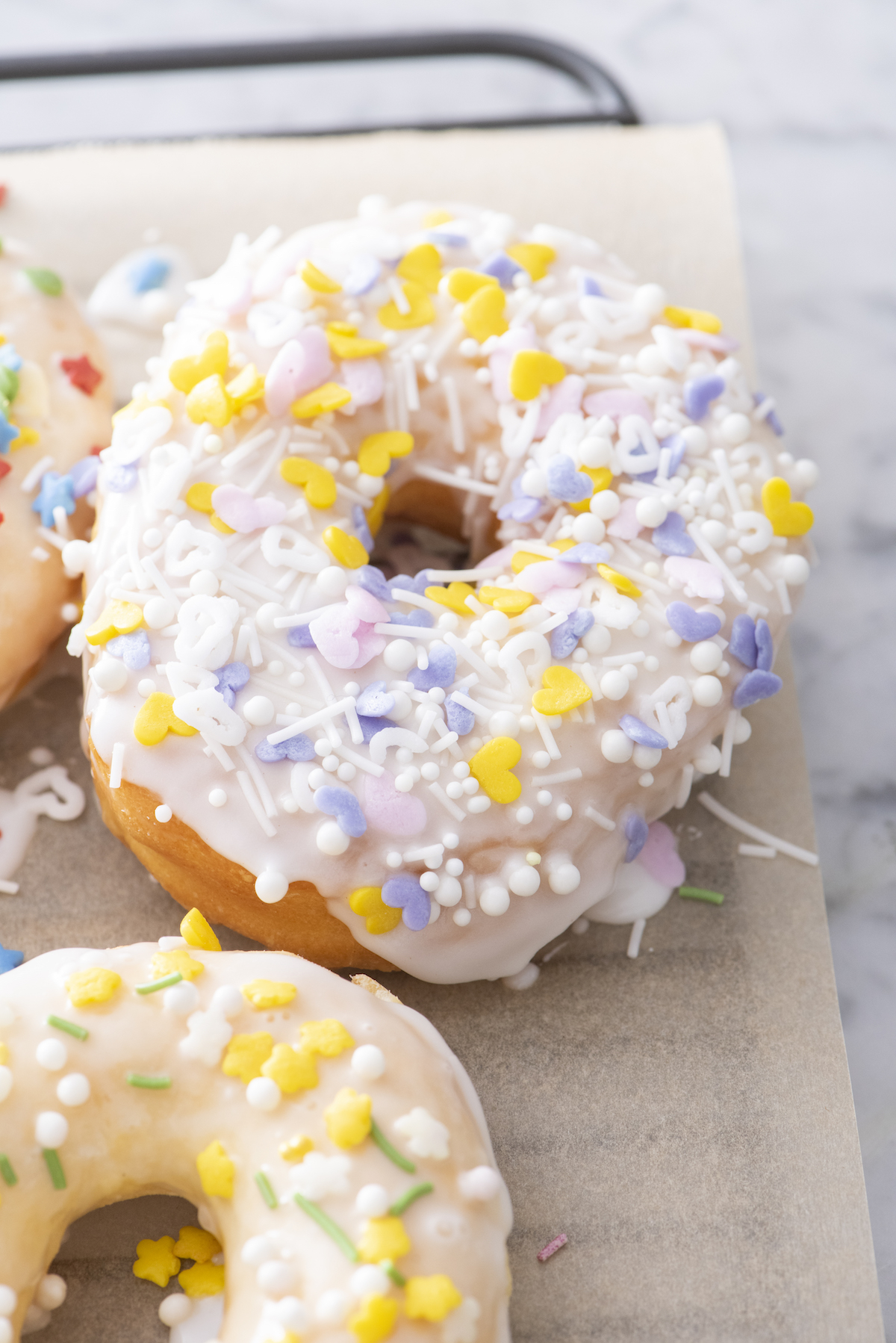 air fryer donuts with yellow, light pink, purple and white sprinkles