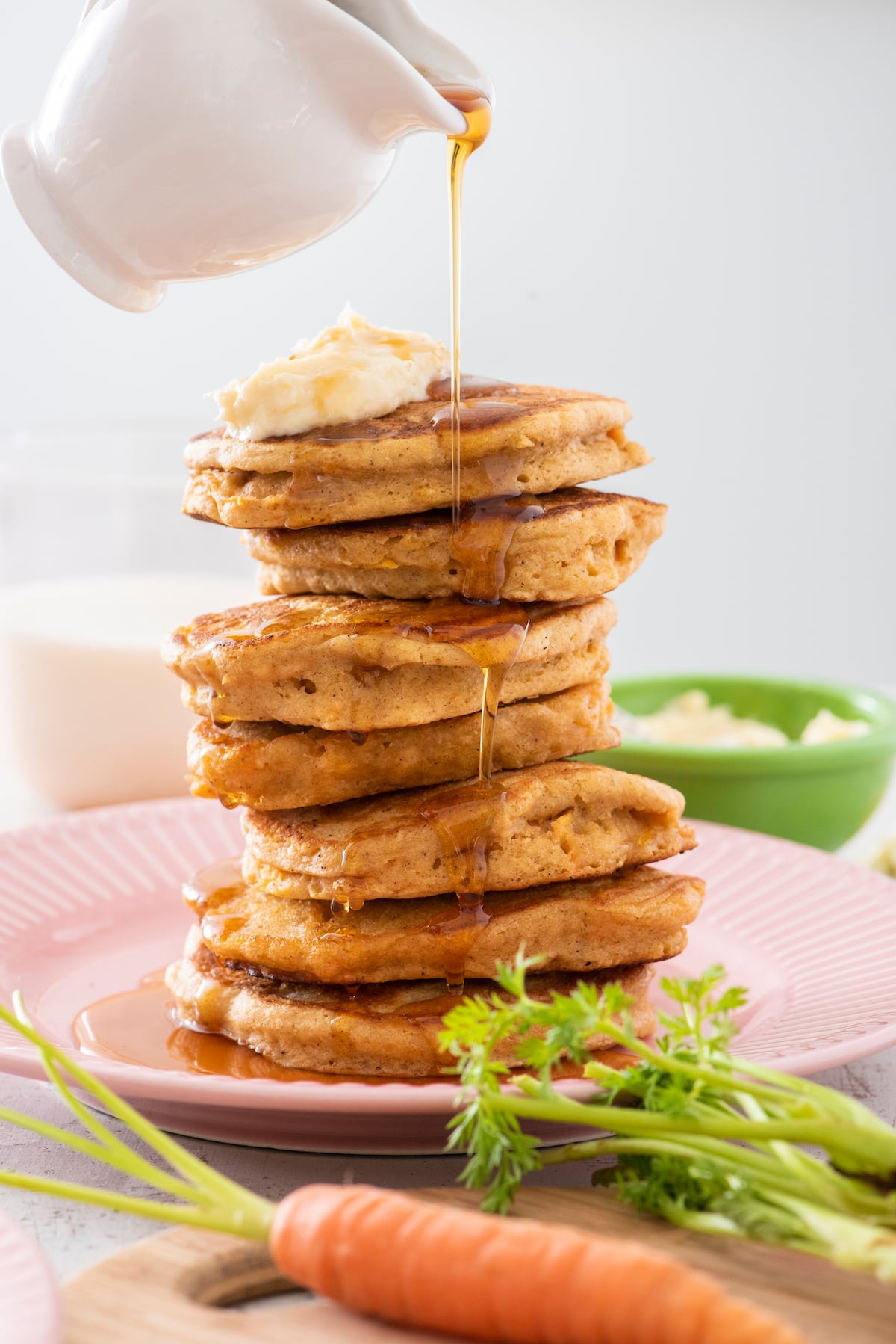 syrup pouring over stack of carrot cake pancakes