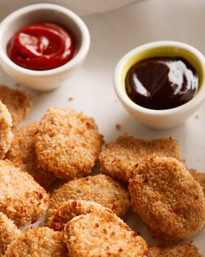 Easy Chicken Nuggets served with BBQ sauce and ketchup for dipping.