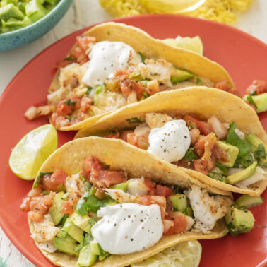 Fish tacos on a red serving platter.