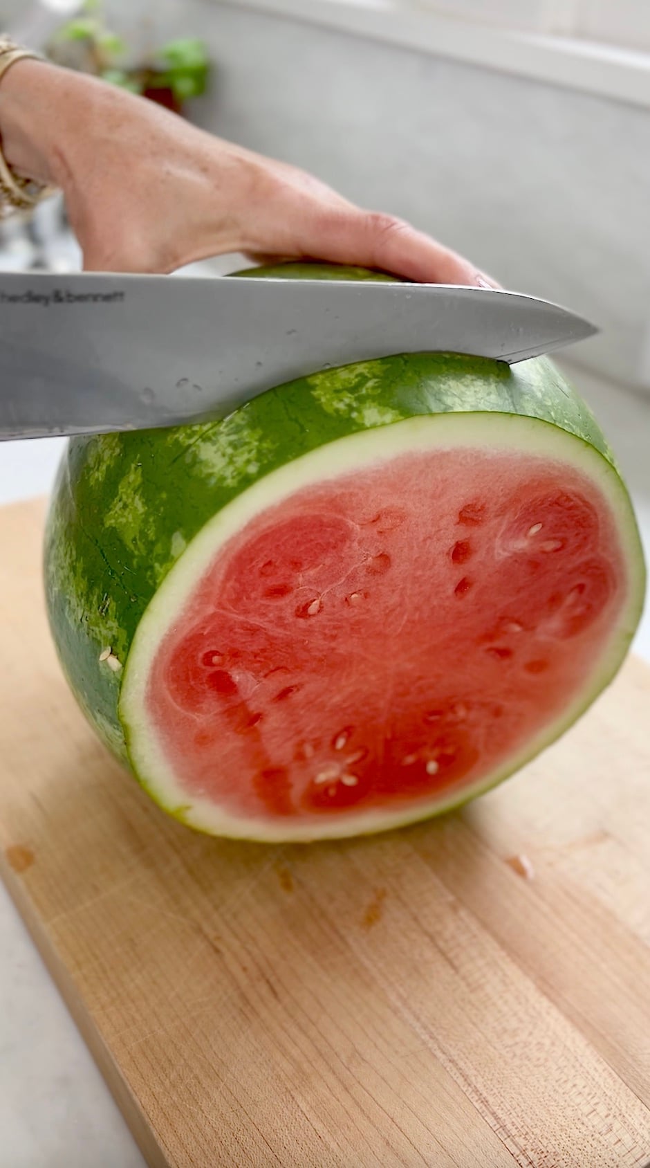 Cutting a watermelon into 1 inch round slice.