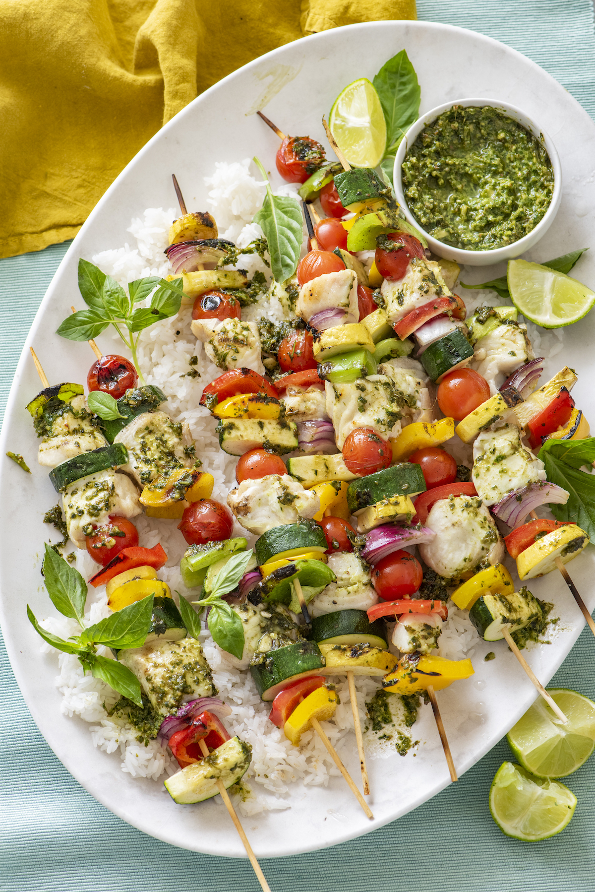 multiple skewers with halibut, bell peppers, red onions, zucchini and yellow squash