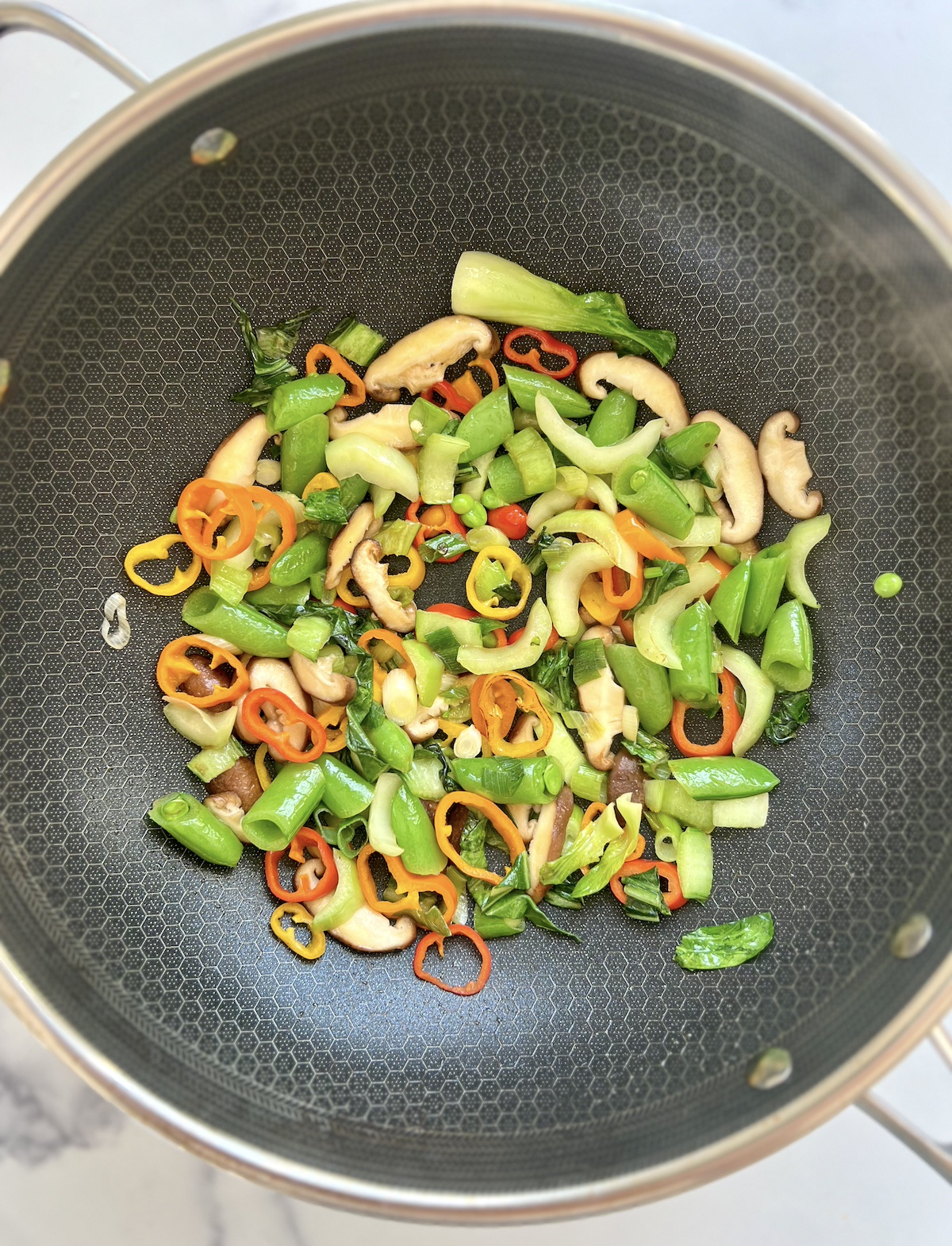 Vegetables sautéing in pan.