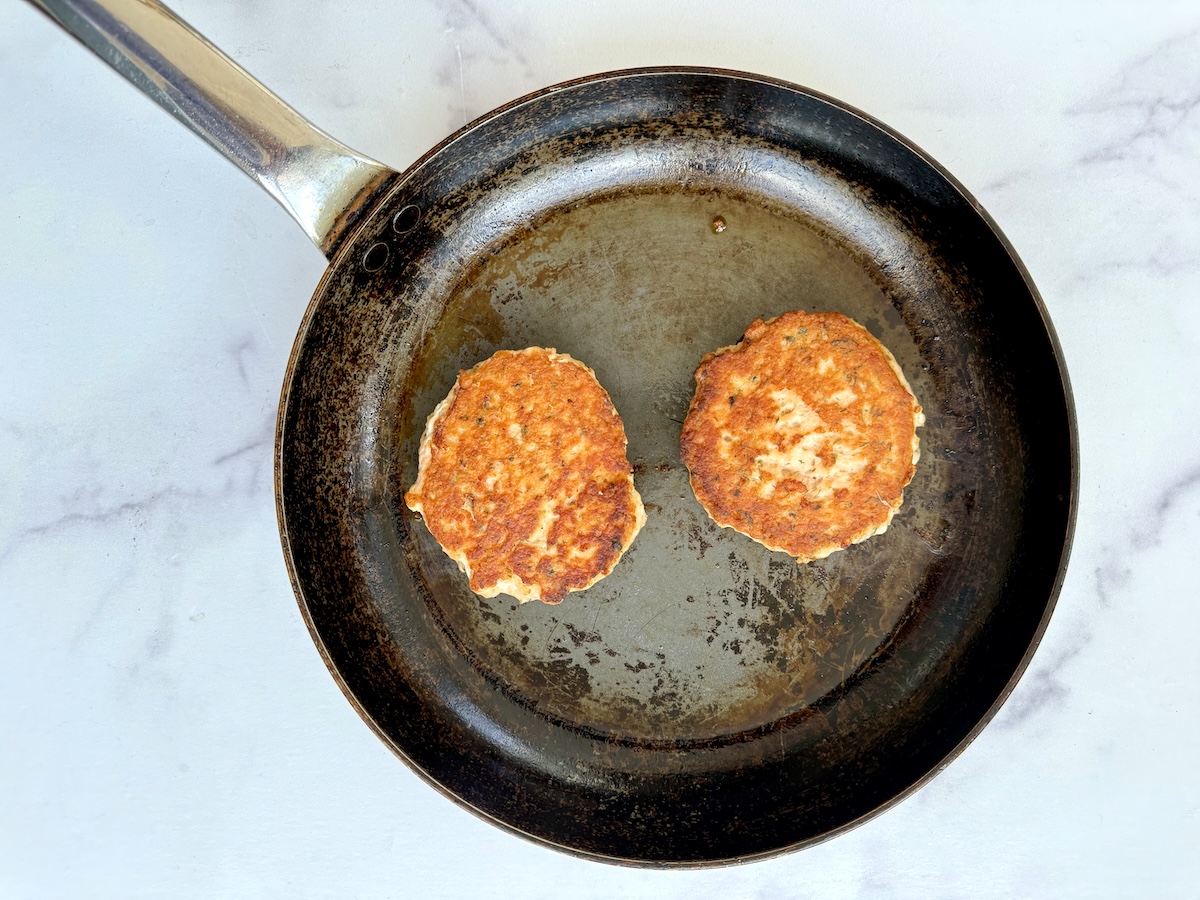Salmon burgers on a saute pan.