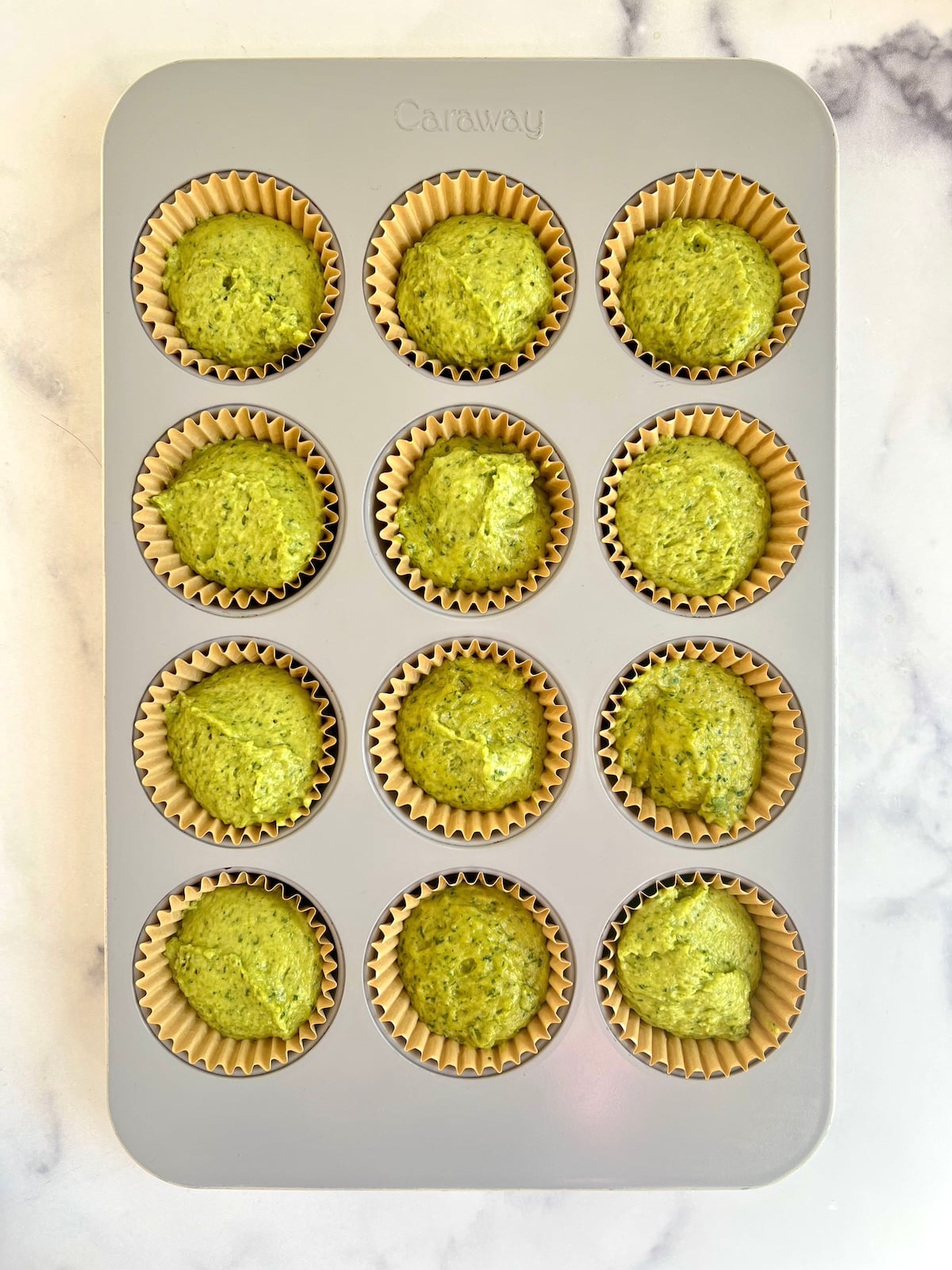 Spinach cake muffins in muffin tin ready to bake.