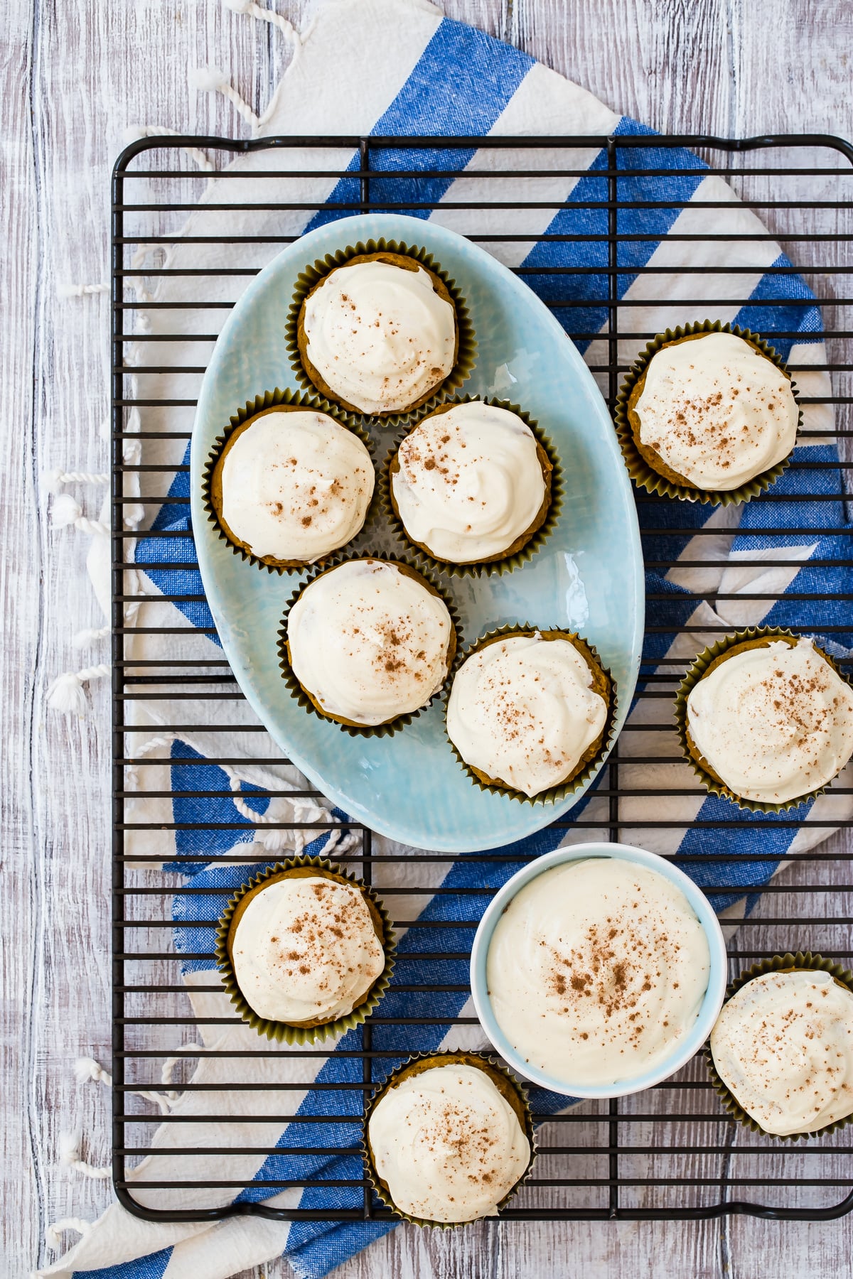 Pumpkin muffins with cream cheese frosting on cooling rack.