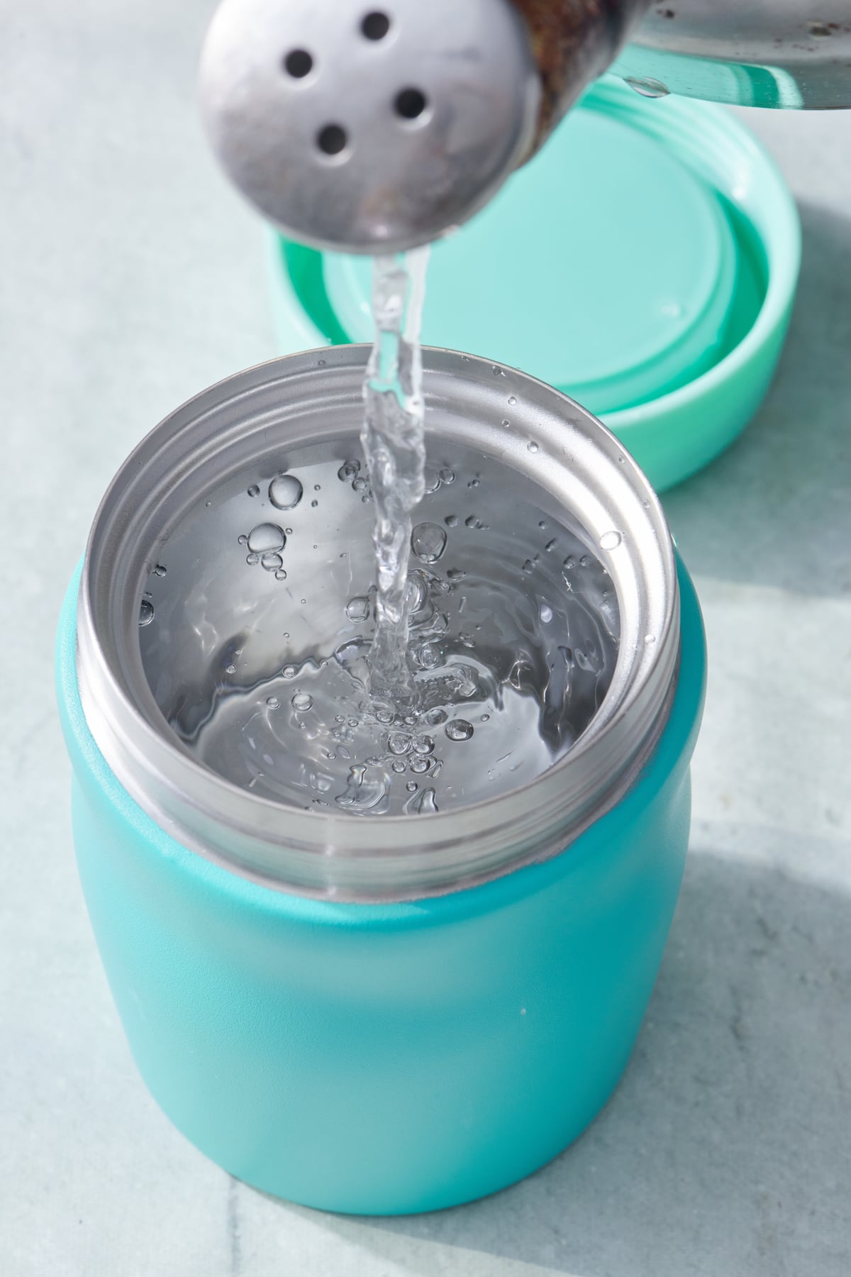 Pouring hot water into a thermos.