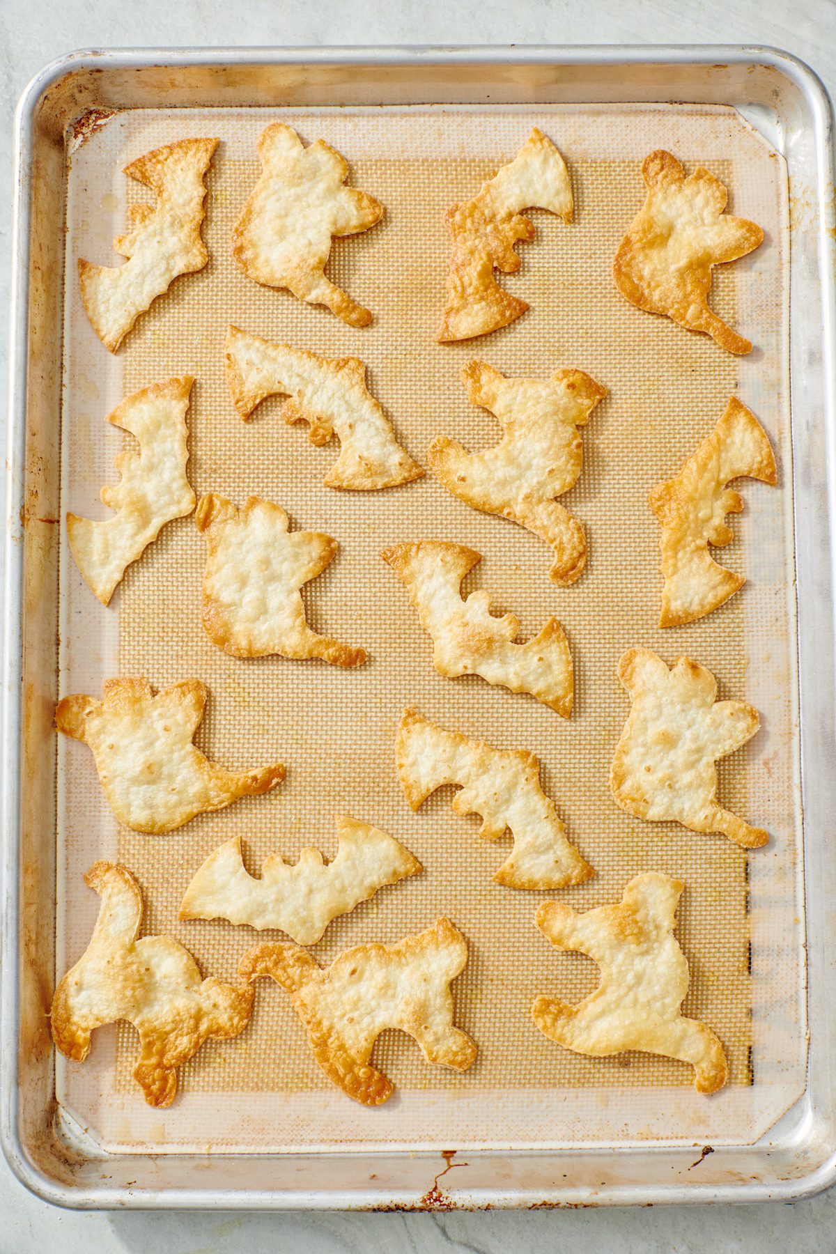 Baked Halloween tortilla chips on baking sheet.