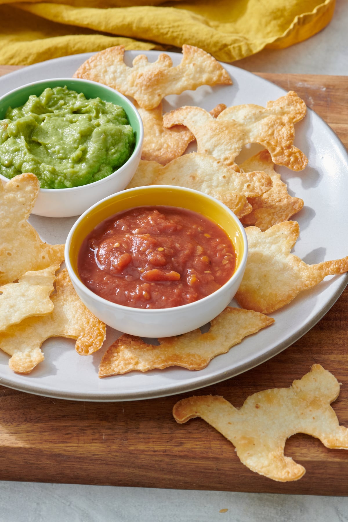 Halloween tortilla chips on plate with salsa and guacamole.