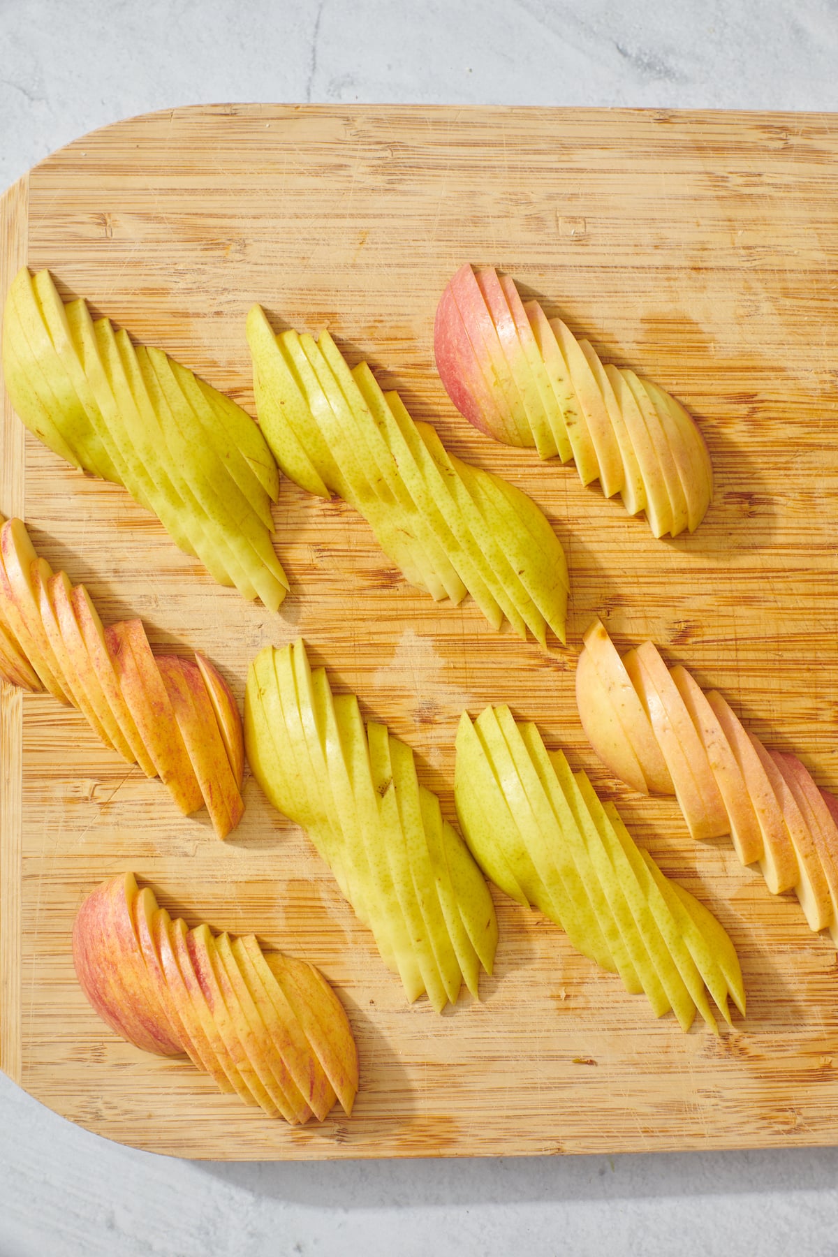 Sliced apples and pears on cutting board.