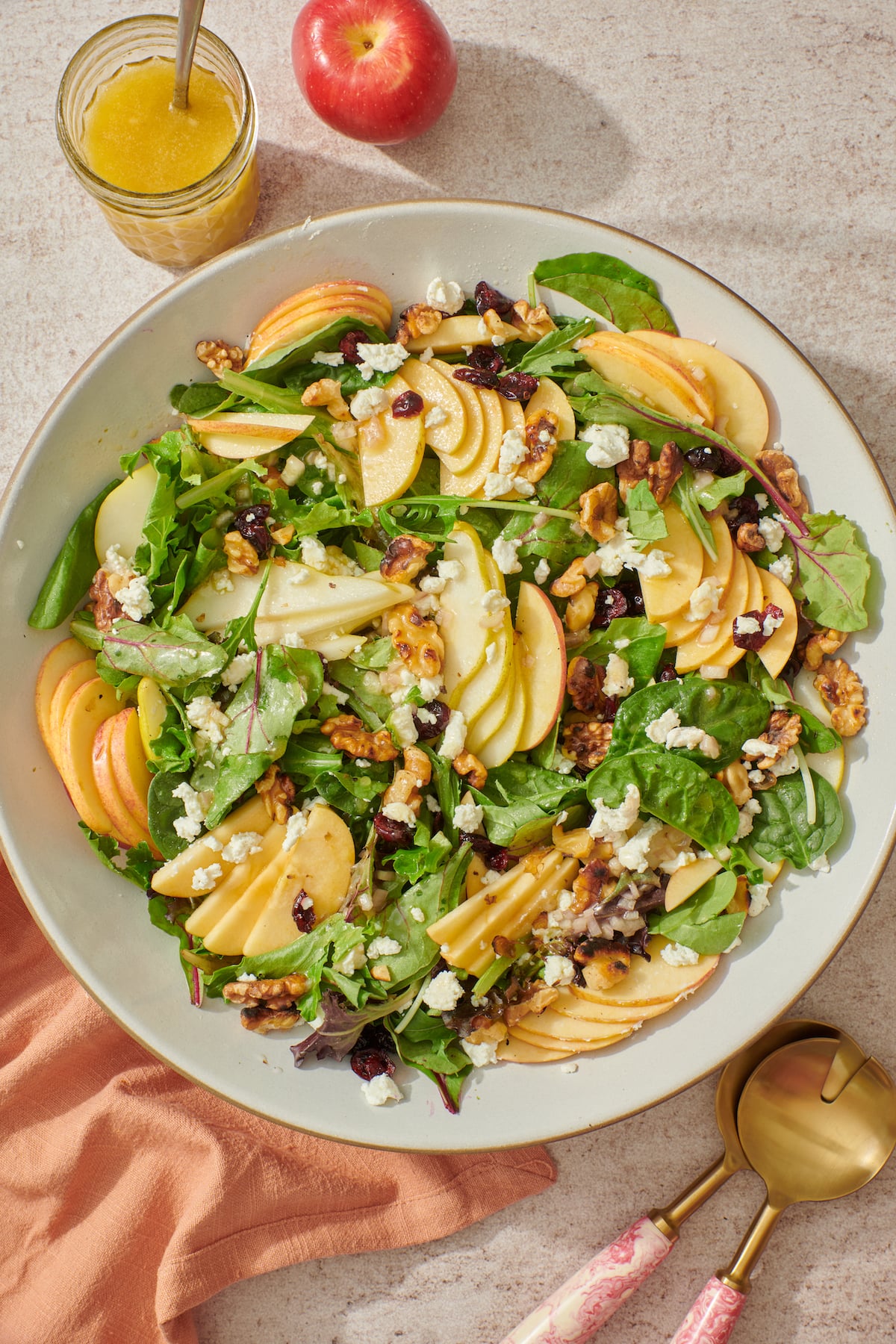 Apple, Pear and Goat Cheese Fall Salad in serving platter with vinaigrette on the side.