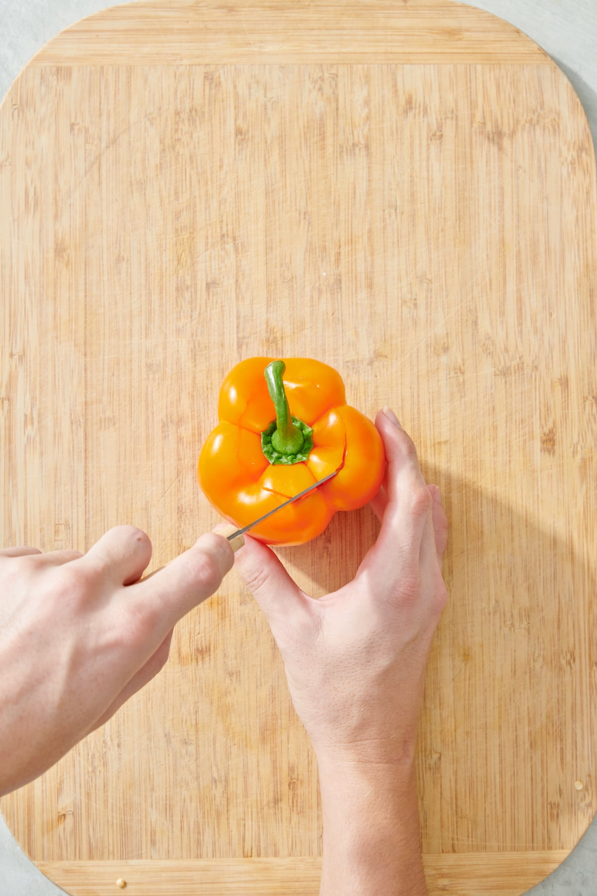 Cutting off the top of pepper.