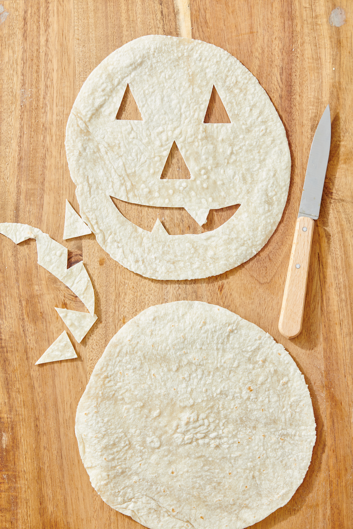 tortillas on cutting board with face cut out.