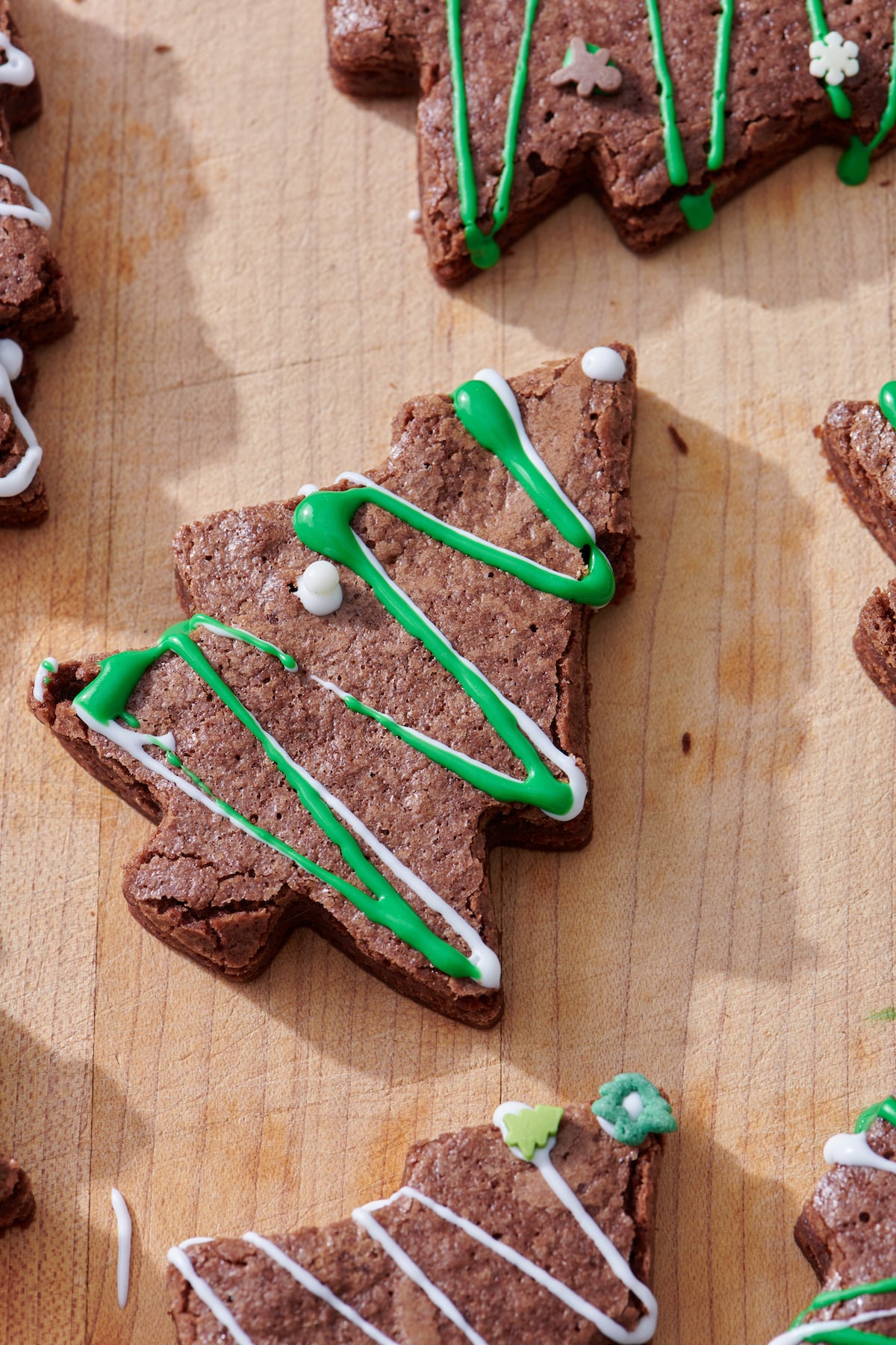 Christmas Tree Brownie with zig zagged green and white frosting and holiday sprinkles.