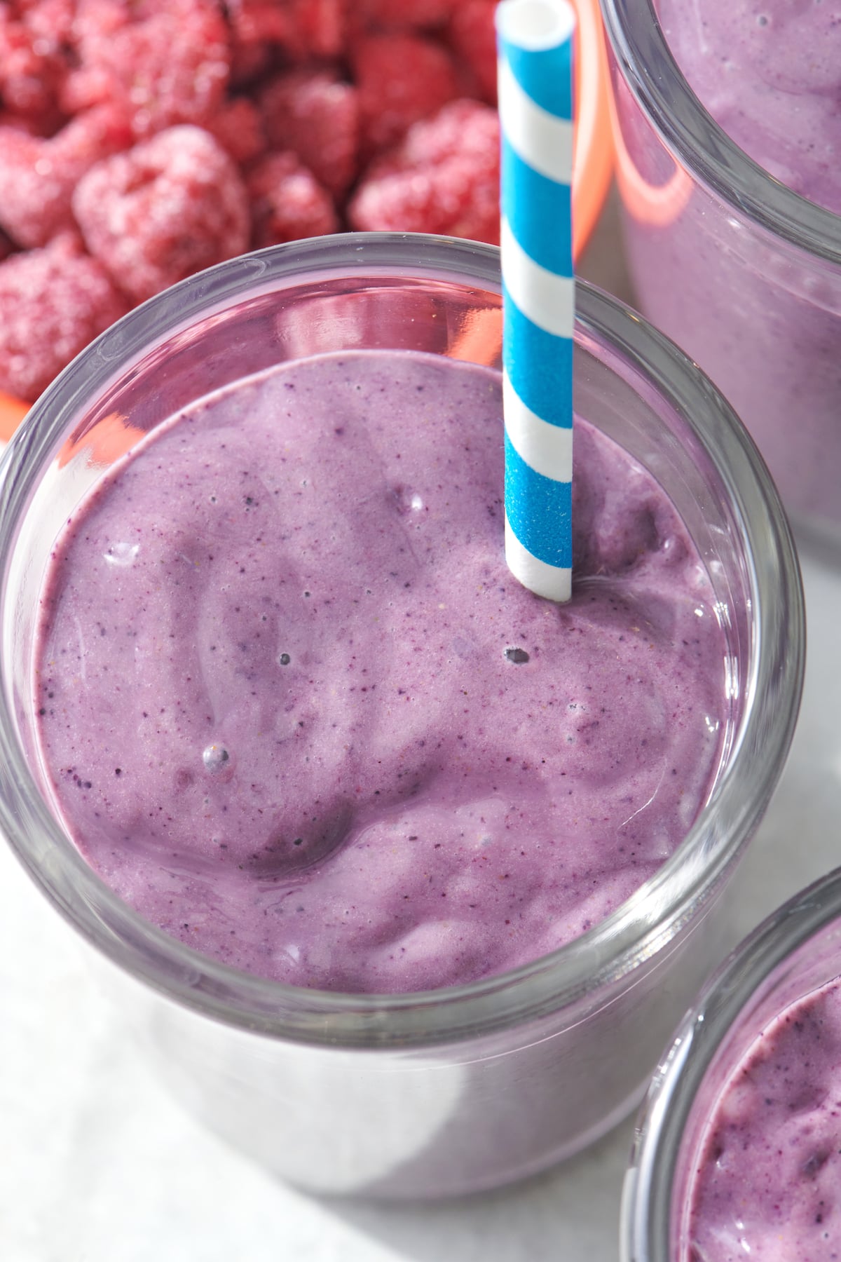 Brain Boosting Smoothie in clear glass with blue striped straw.