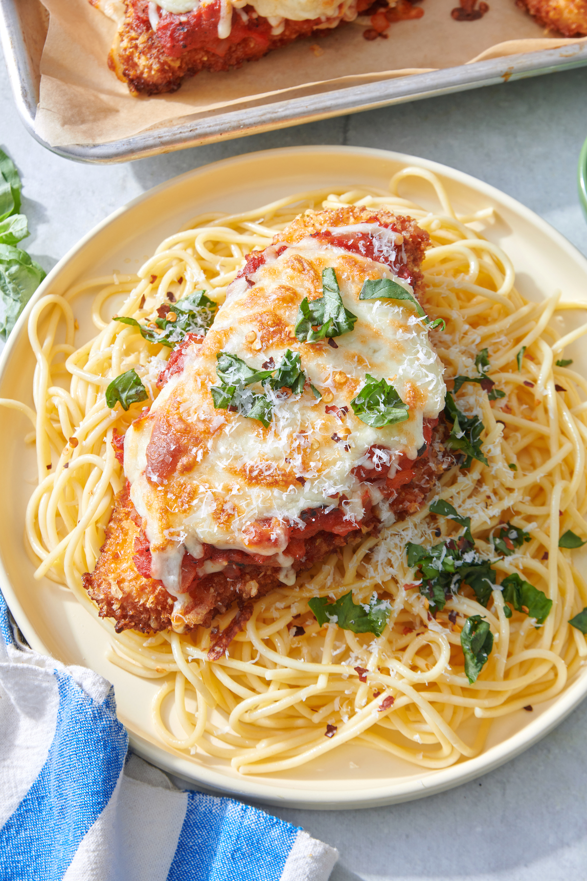 Crispy Chicken Parmesan on bed of spaghetti noodles.