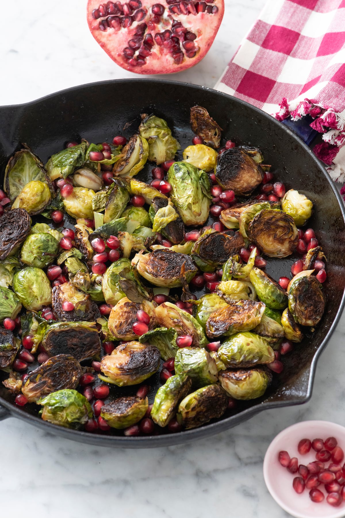 Brussels Sprouts with Pomegranate and Garlic in cast iron pan.
