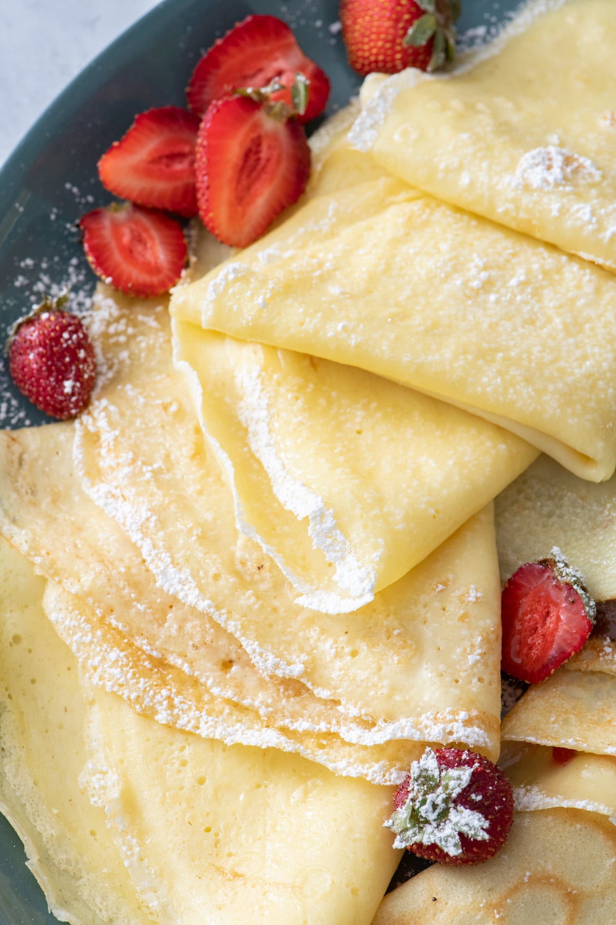 Crepes folded with no fillings. Topped with powdered sugar and strawberries.