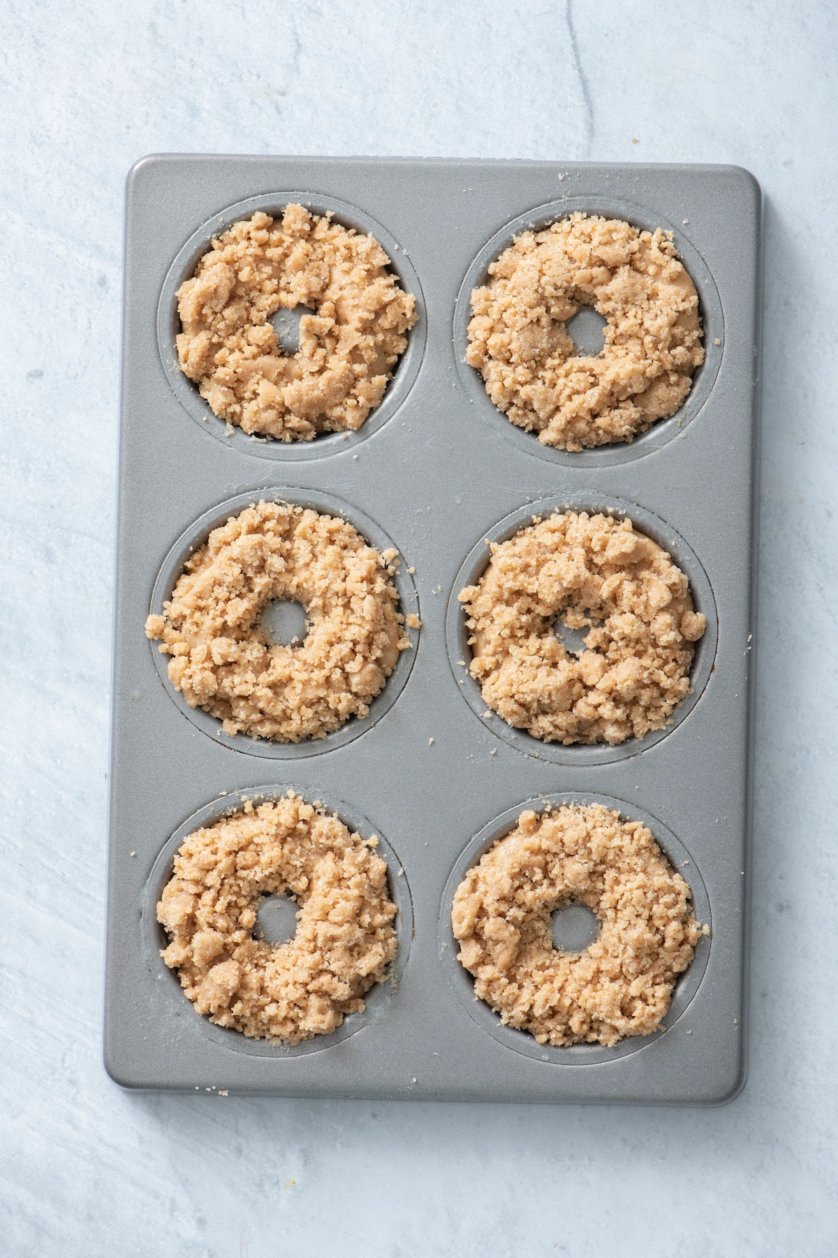 crumb topping added to donut batter in donut pan