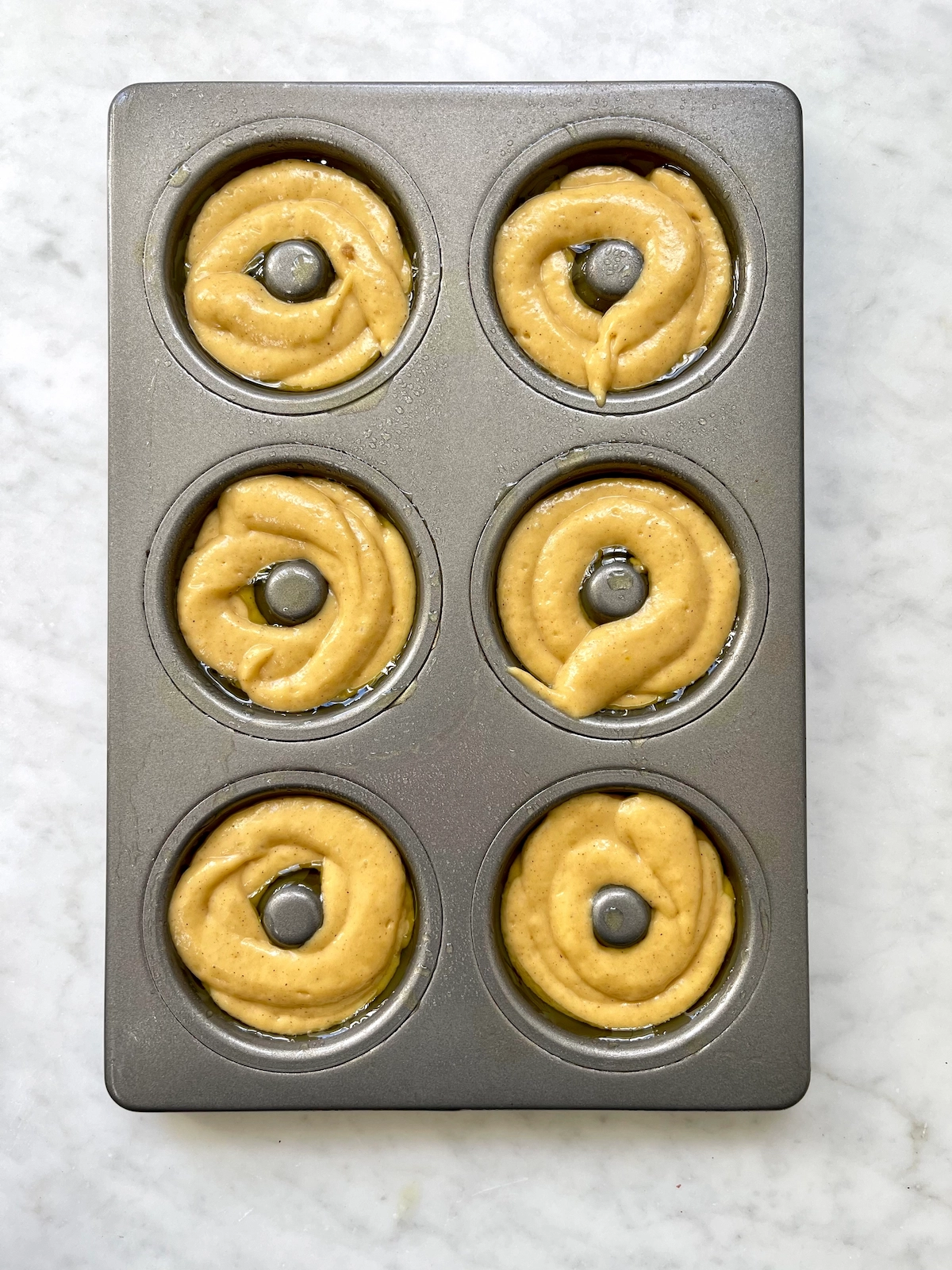 donut batter piped into donut pan
