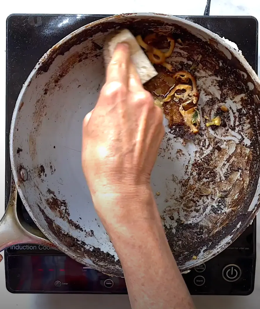 wiping away grime in pan