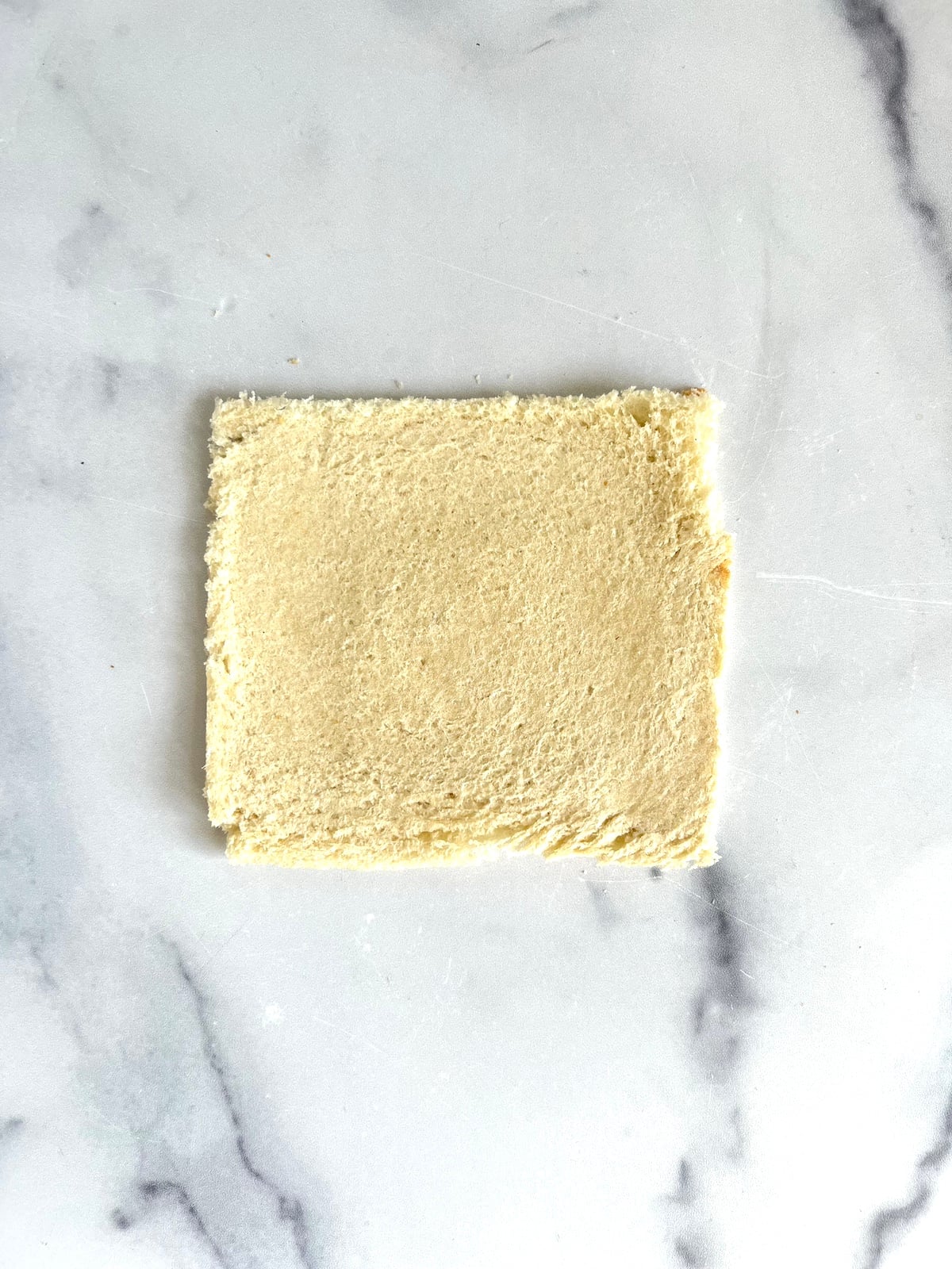 Flattened out piece of sandwich bread.