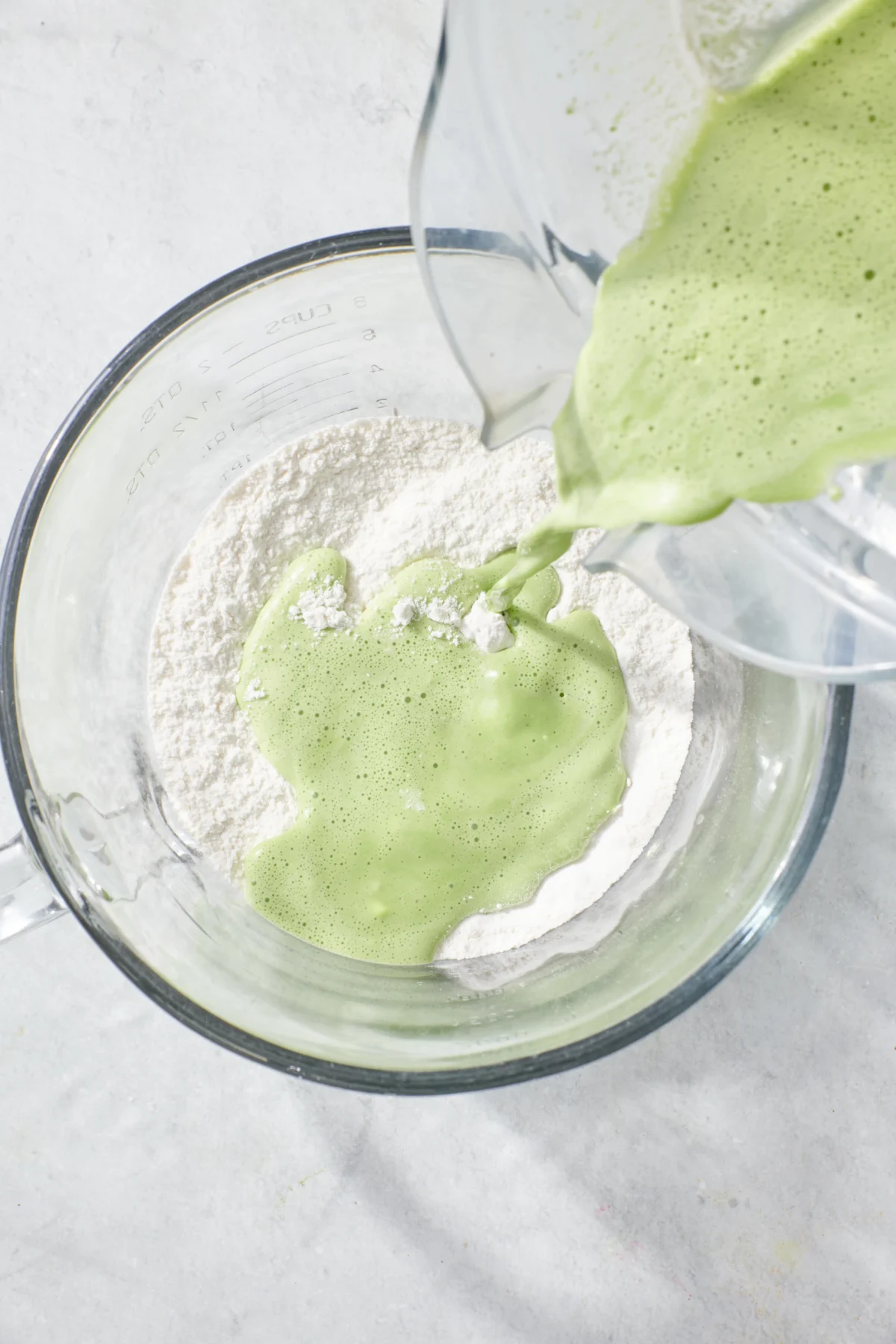 Mixing wet and dry ingredients for pancakes with spinach.