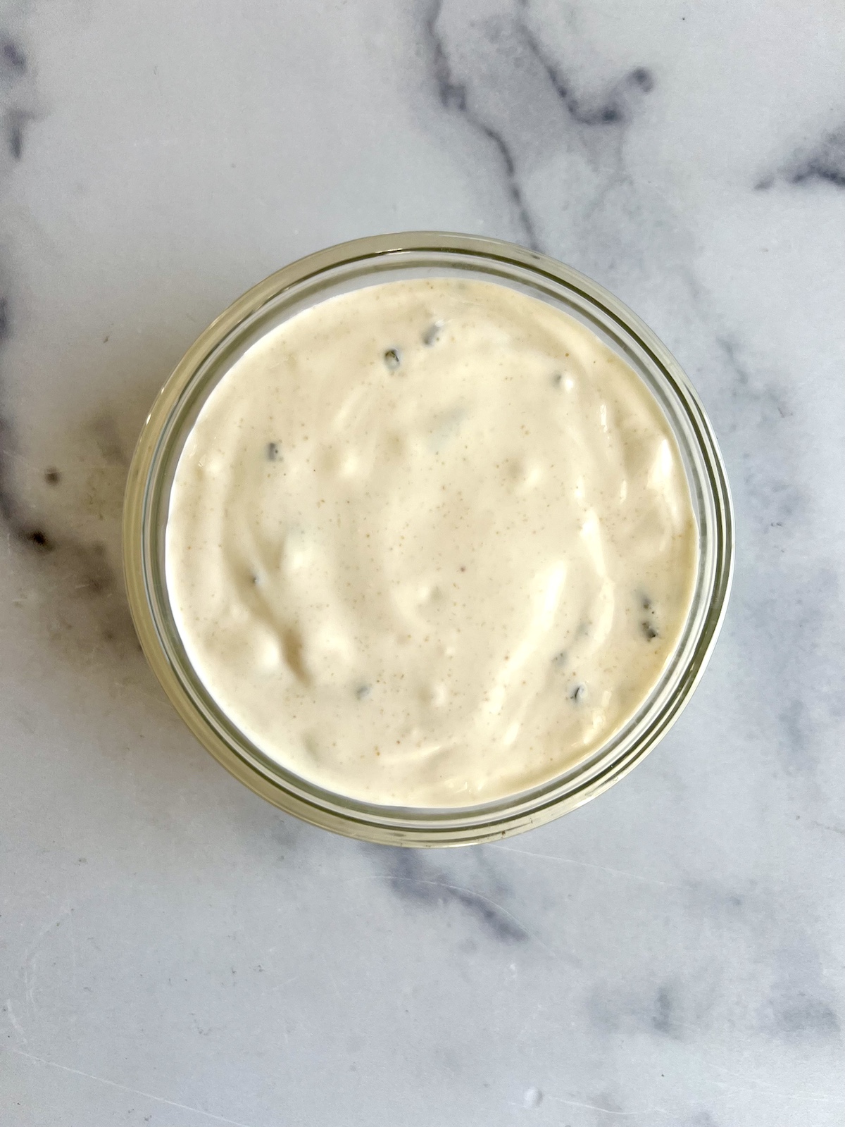 Creamy garlic dip in small bowl.
