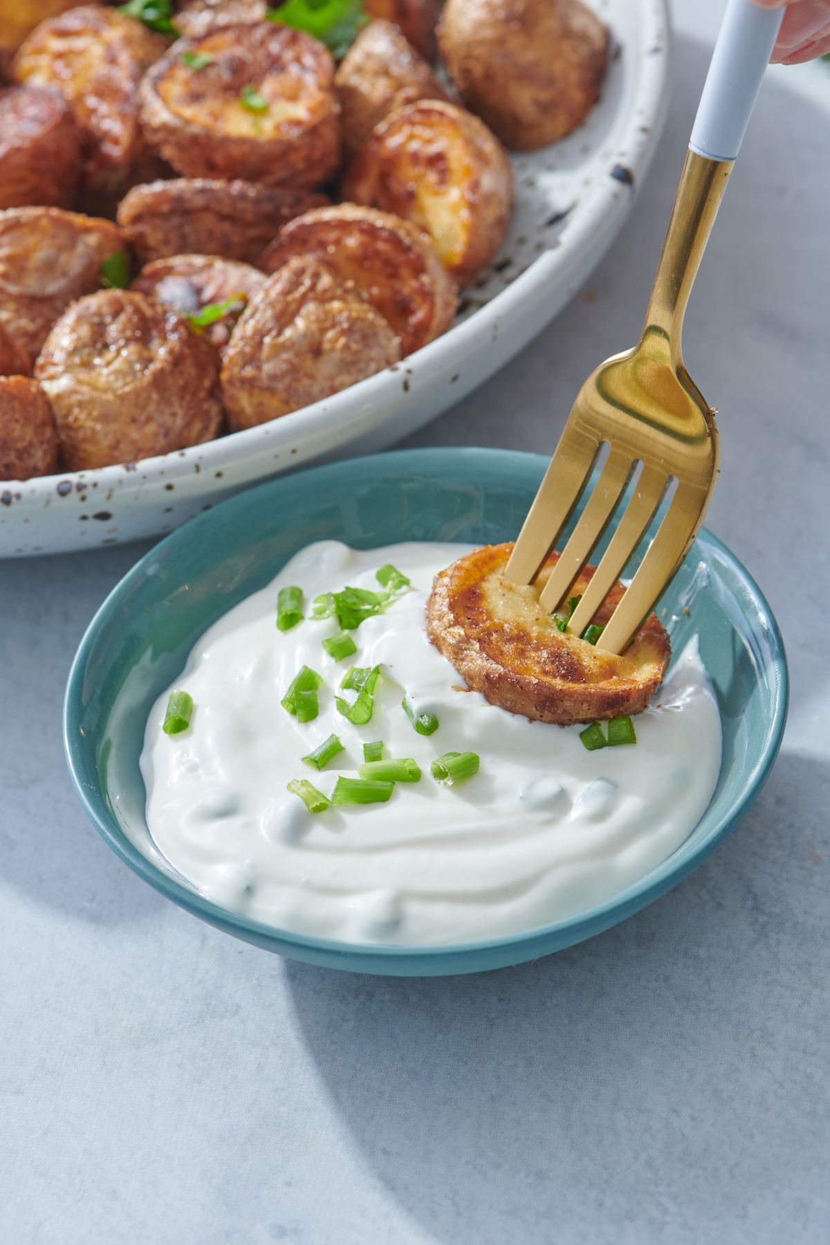 Dipping air fried potato in garlic dip.