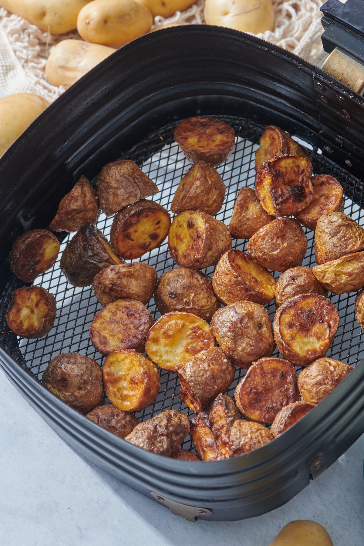 Baby potatoes cooked in air fryer basket.