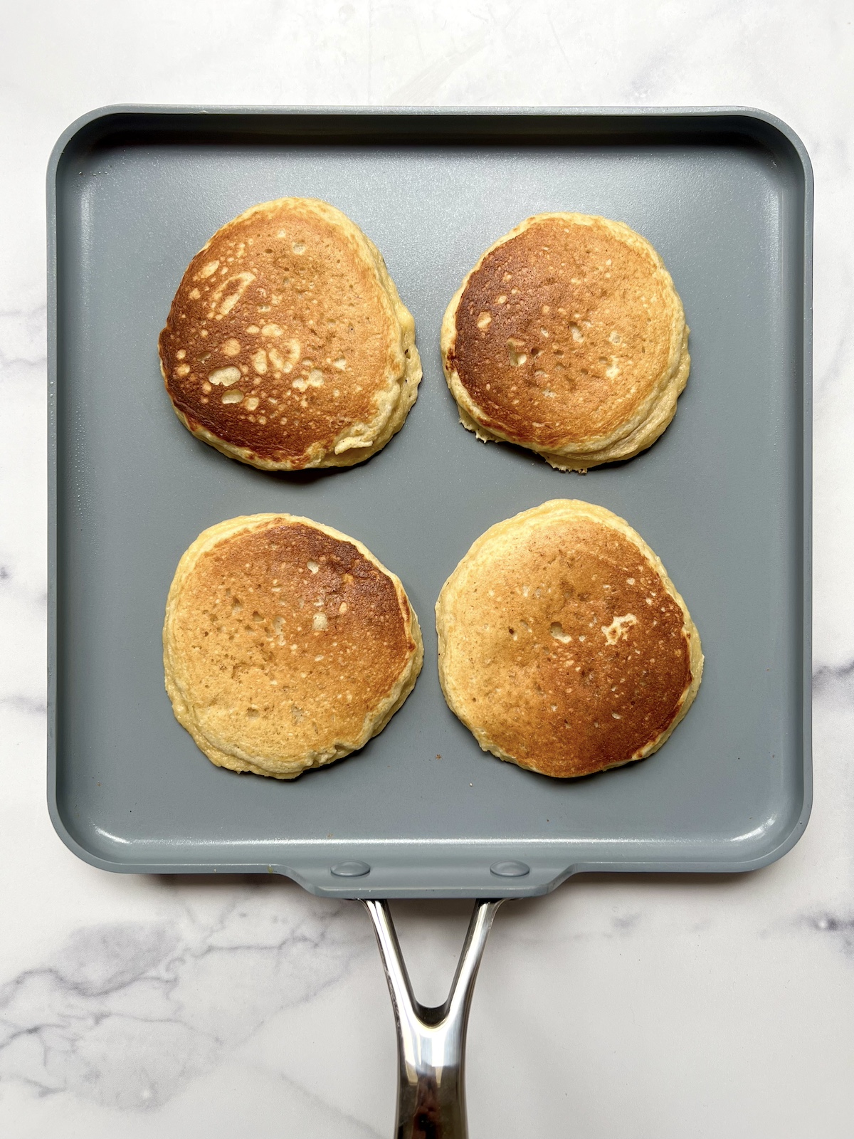 Almond flour banana pancakes being cooked on sauté pan.