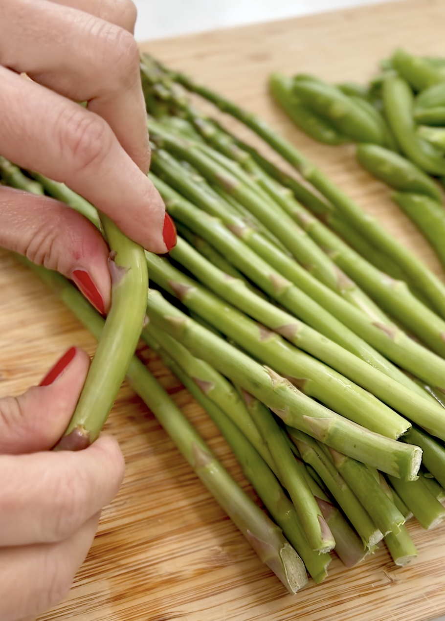 hands snapping an asparagus spear at its natural break.
