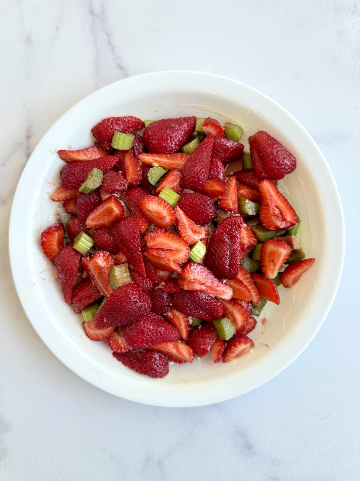 Strawberry rhubarb filling in pie dish before crumble topping.