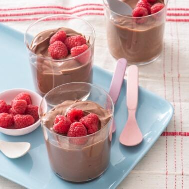 Chocolate Tofu Pudding in clear glasses topped with raspberries.