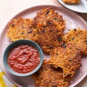 Spaghetti cakes on pink serving platter with marinara.