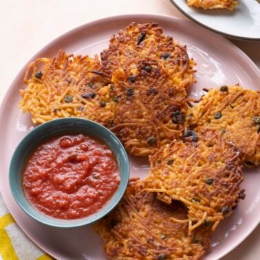 Spaghetti cakes on pink serving platter with marinara.