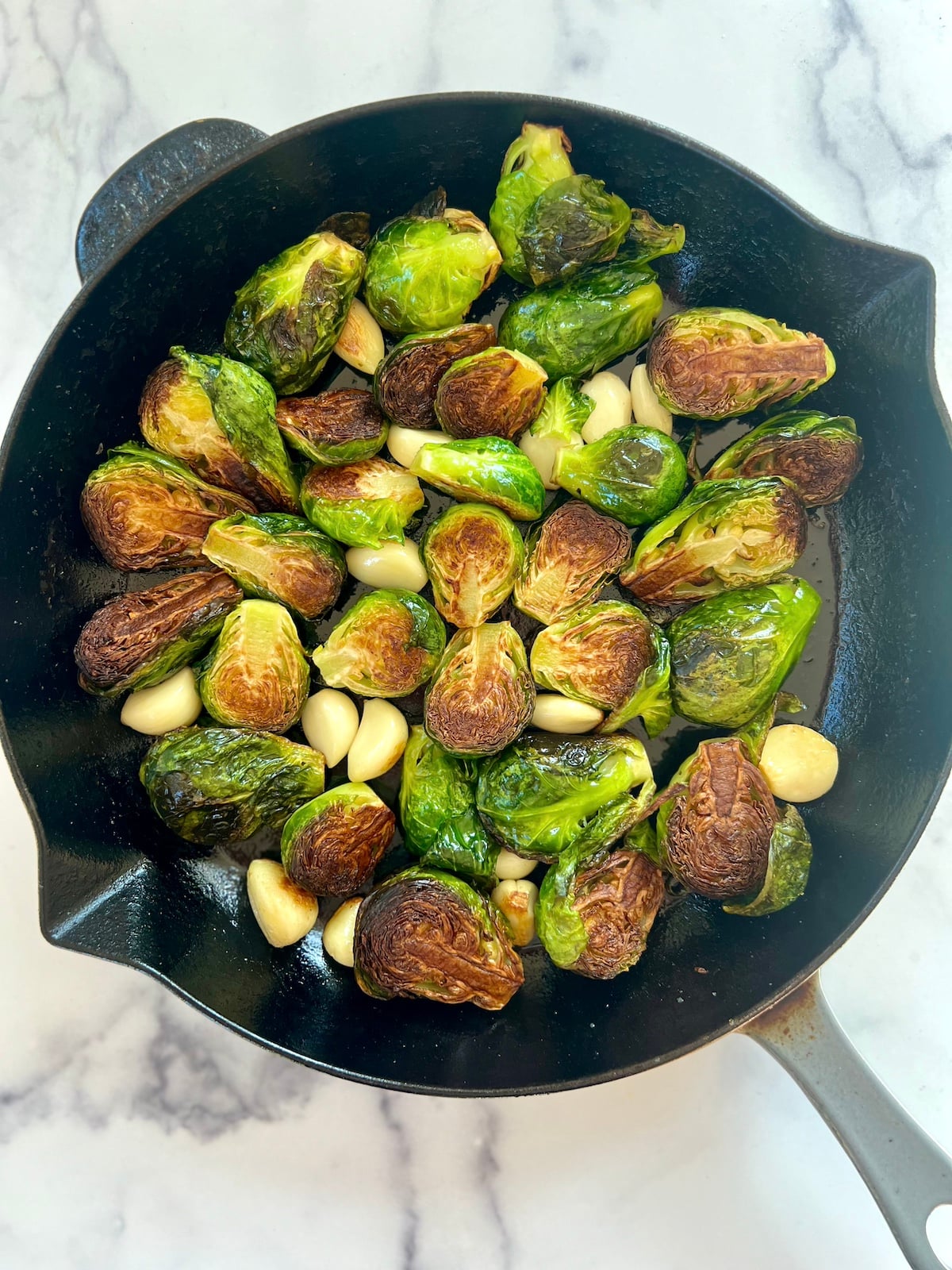 Browned Brussels sprouts in a cast iron skillet.