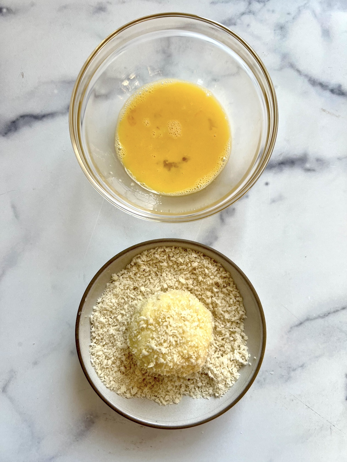 Breading a croquette in breadcrumbs and eggs.