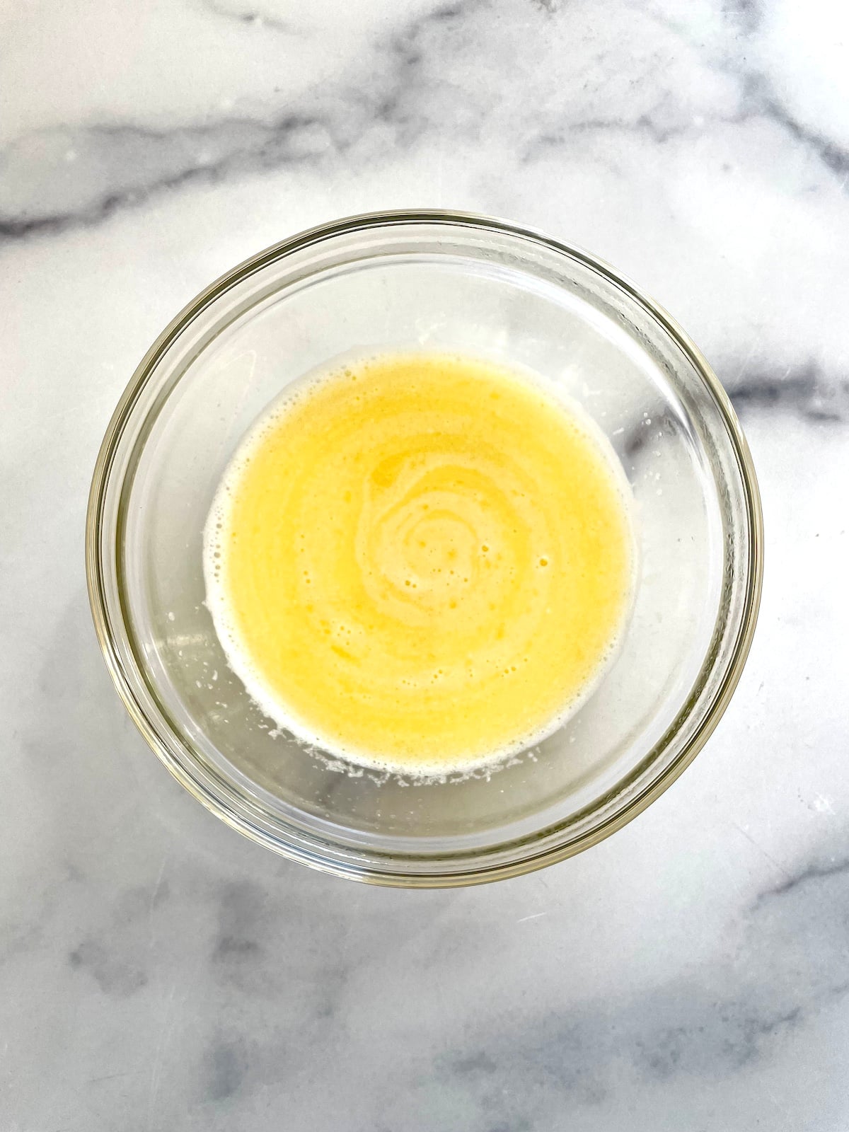 Melted butter and milk in a small bowl.