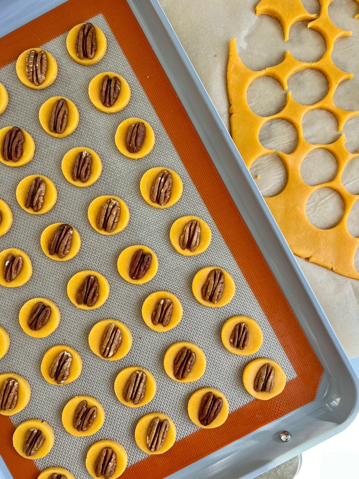 Raw cheese wafers on a baking sheet.