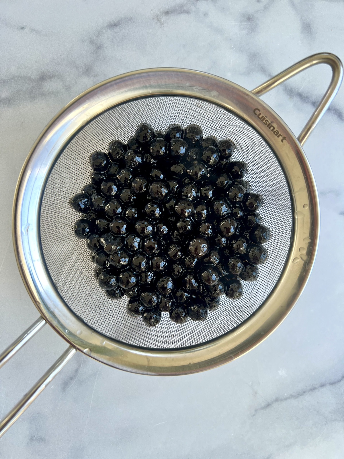 Tapioca pearls (boba) in colander.