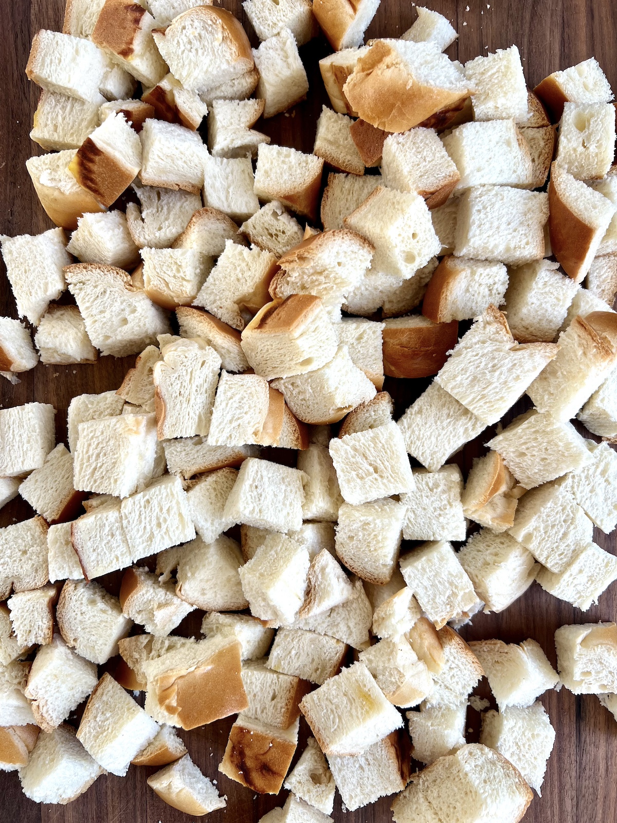 Cubed bread on a cutting board.