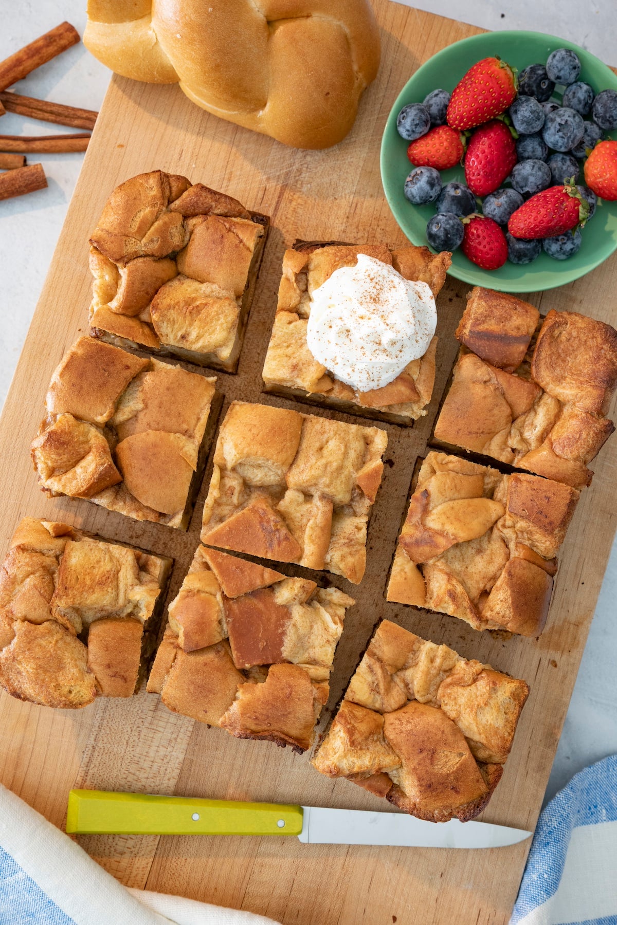 Slices on challah bread pudding on cutting board.